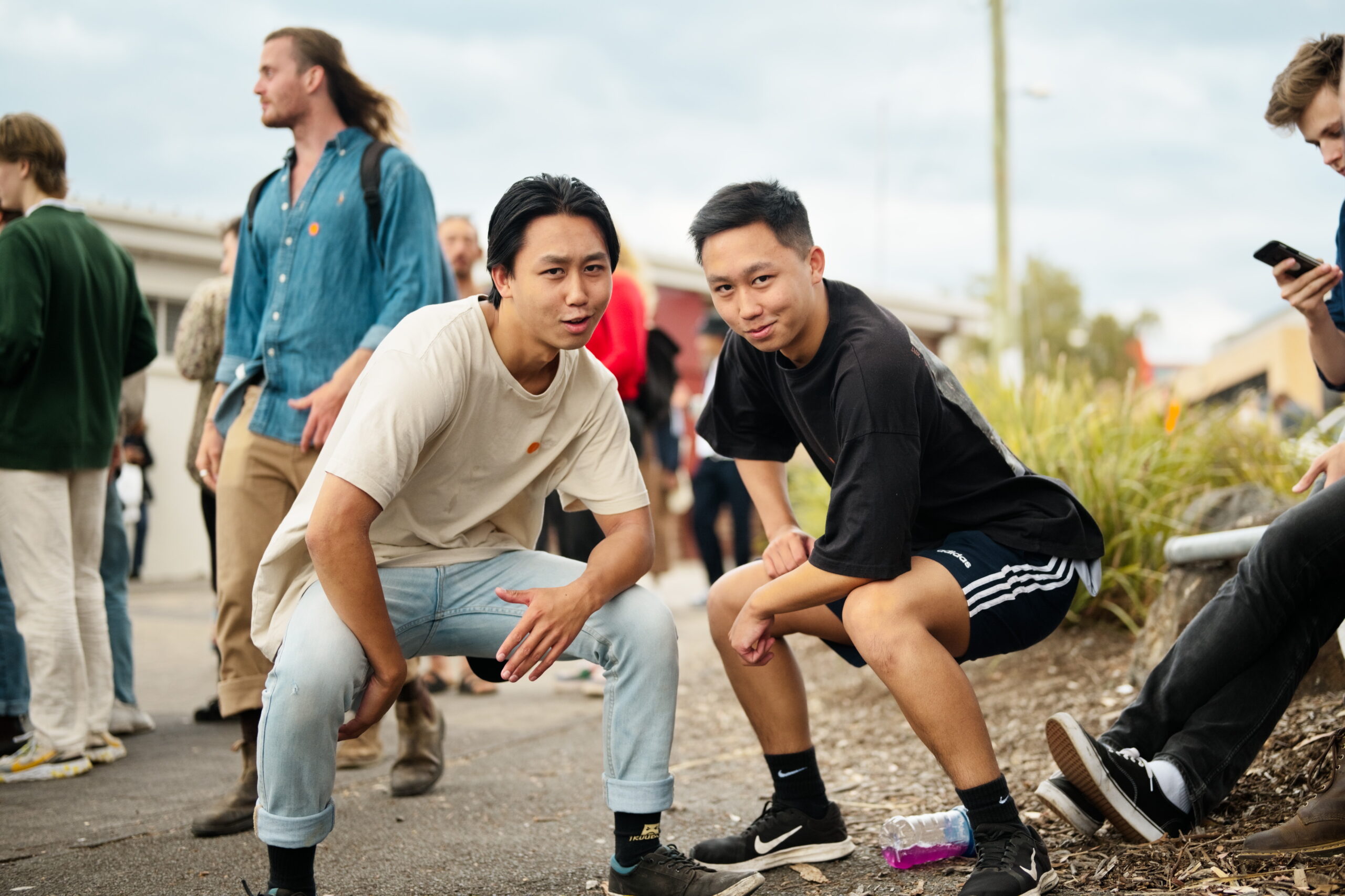 Photo of two young men crouching and smiling
